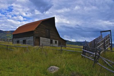 Barn on field against sky