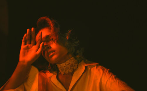 Portrait of young man against black background