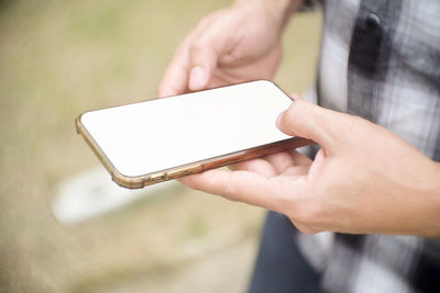 Midsection of man using mobile phone