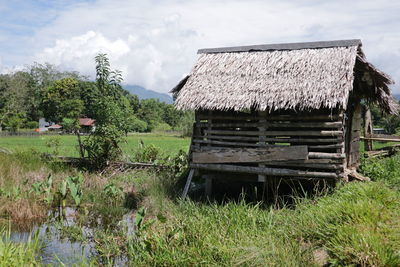 Abandoned house on field against sky