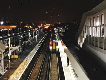 Railroad tracks at illuminated station at night