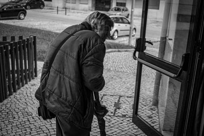 Rear view of man standing on footpath