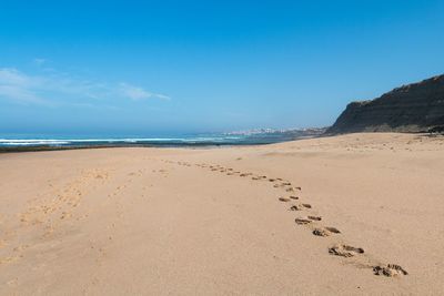 Scenic view of beach against blue sky