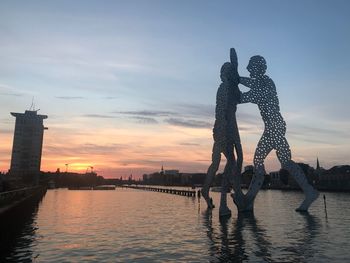 Sculpture of bridge over river during sunset