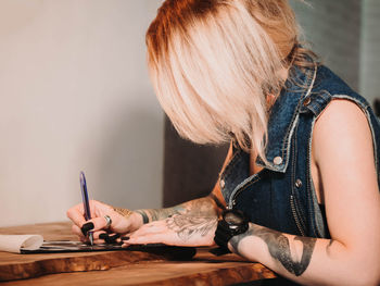 Close-up of tattooist drawing at table