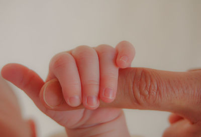 Cropped hands of baby and parent