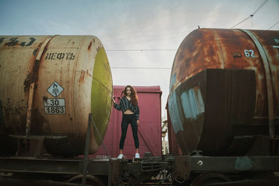 Young woman standing on abandoned freight train