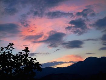 Silhouette of mountain against cloudy sky at sunset