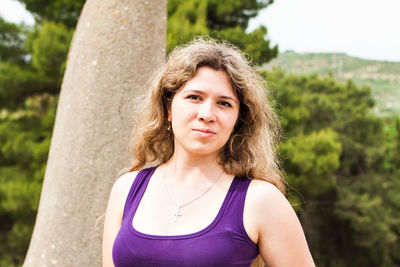 Portrait of smiling woman against trees