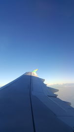 Airplane wing against blue sky