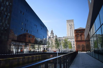 Bridge over canal amidst buildings against sky in city