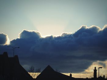 Low angle view of silhouette roof against sky