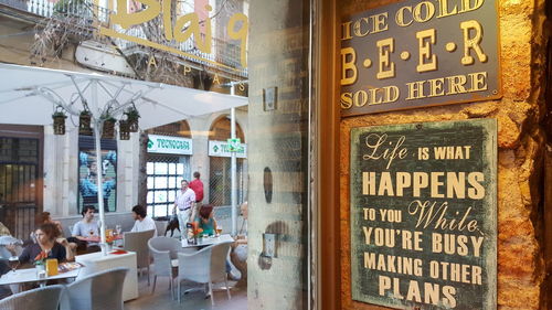 Information sign on table in restaurant against buildings in city