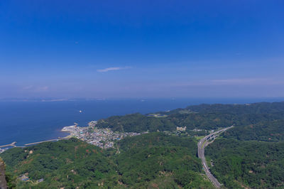 Scenic view of sea and mountains against blue sky