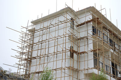 Low angle view of building under construction against sky