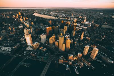 High angle view of city lit up at sunset