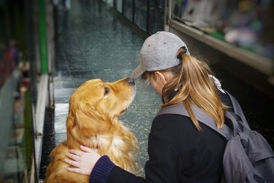 Woman with dog sitting in corridor