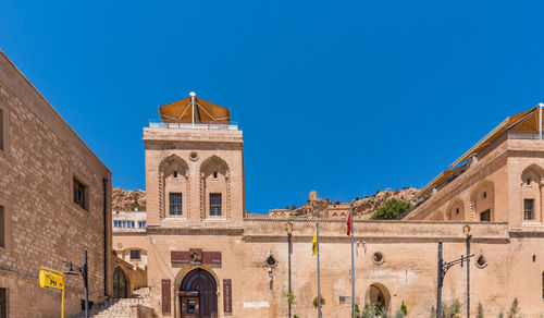 Low angle view of historic building against clear blue sky