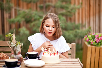 Happy girl sitting on table