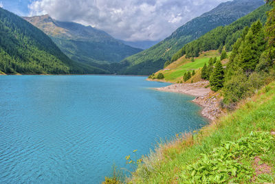 Scenic view of lake by mountains against sky