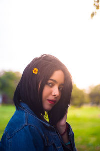 Portrait of young woman against sky