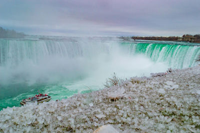 Scenic view of waterfall against sky