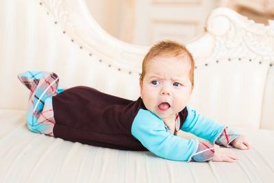 Portrait of cute baby lying on floor at home