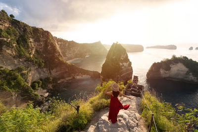 Rear view of woman standing on rock