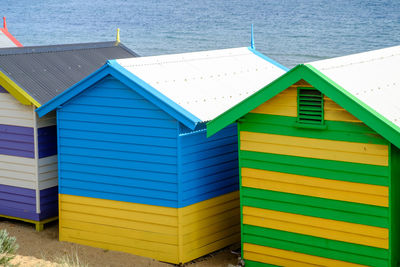 Multi colored beach huts against blue sky