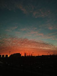 Silhouette cityscape against sky at sunset