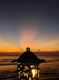 Silhouette people on beach against sky during sunset