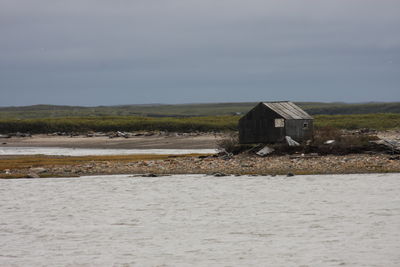 House on beach by sea against sky