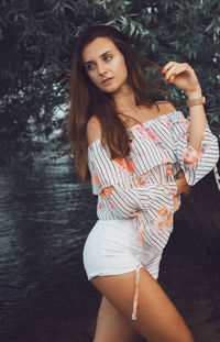 Portrait of a beautiful young woman standing in sunlight