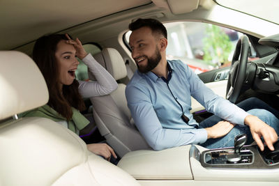 Young woman using phone while sitting in car