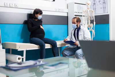 Rear view of doctor examining patient in hospital