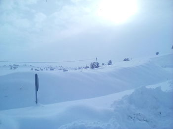 Snow covered landscape against sky