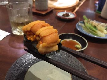 Chopsticks with sushi over table