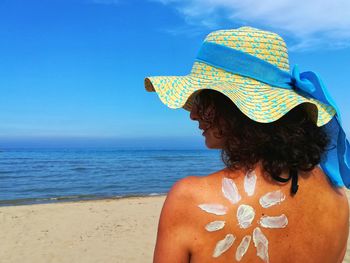 Rear view of woman looking at sea against sky