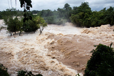 Scenic view of waterfall against sky