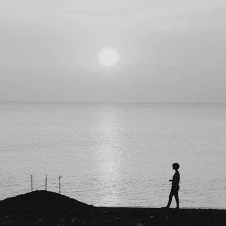 water, sea, horizon over water, standing, tranquility, tranquil scene, silhouette, lifestyles, leisure activity, scenics, full length, beauty in nature, rear view, nature, men, sky, idyllic, beach