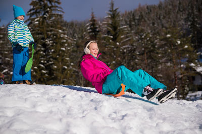 Full length of girl on snow covered tree