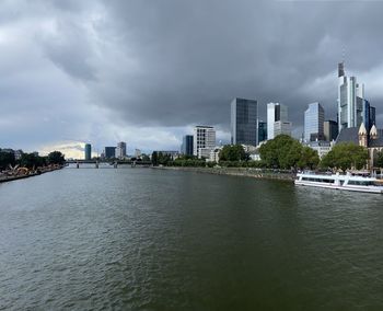 River by buildings in city against sky