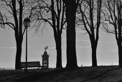 Silhouette trees on field against sky