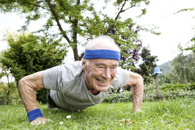 Senior man doing pushups for fitness training in garden