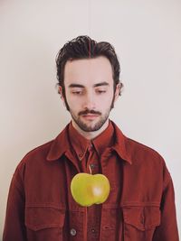 Portrait of young man standing against white background