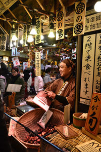 Woman at market stall at night