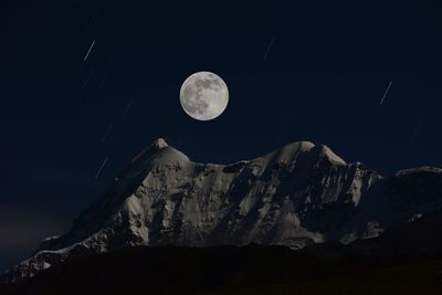 Scenic view of snowcapped mountains against sky at night