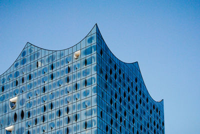 Low angle view of modern building against clear blue sky
