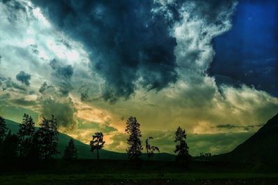 Scenic view of silhouette landscape against storm clouds