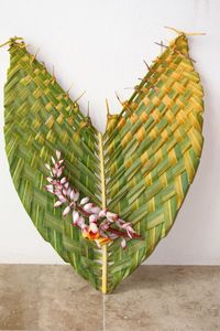 Close-up of flowers on woven palm leaf